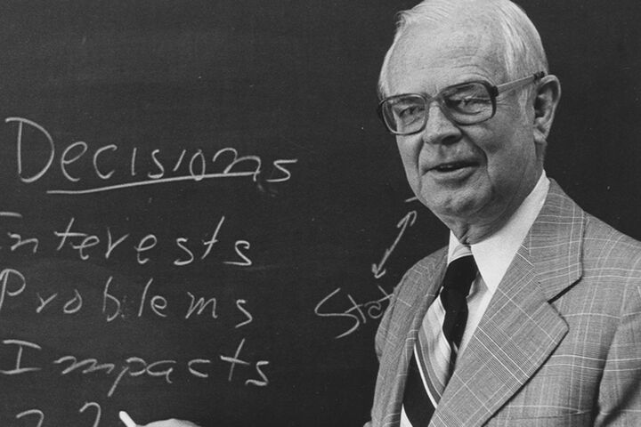 Dr. Robert Shaffer stands in front of a chalkboard.
